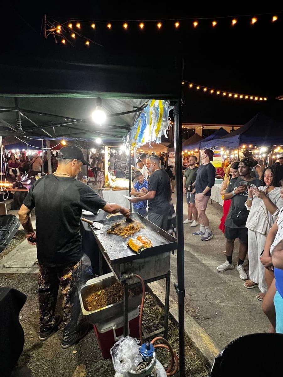 People at a food stall at an evening street market