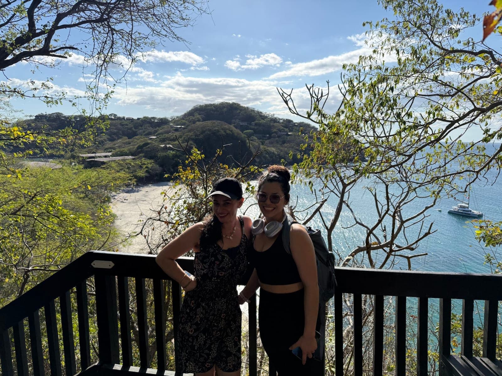 Two hikers smiling at a wooden lookout above a bay on the Papagayo Peninsula