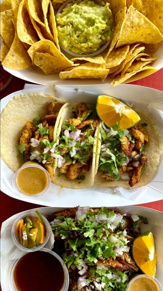 Plates of tacos, chips and guacamole at Gritanga