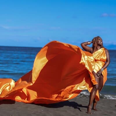 Glow Collection Photoshoot – A stunning moment captured in a vibrant, shimmering orange dress, glowing under Guanacaste’s natural light.